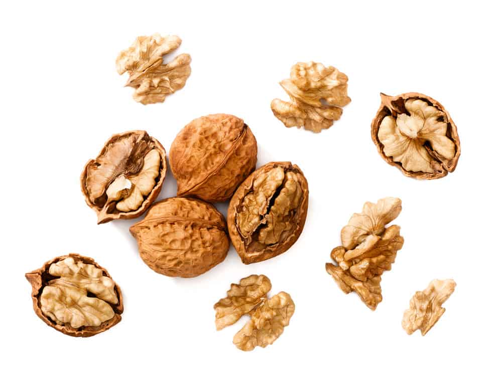 cracking walnuts on white, top view.
